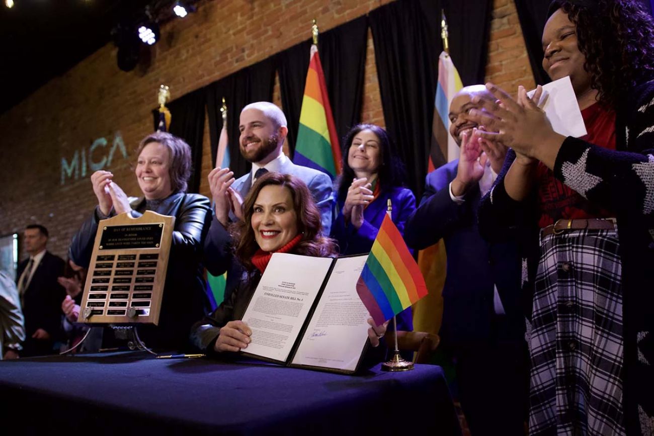 Gov. Gretchen Whitmer surrounded by people and pride flags