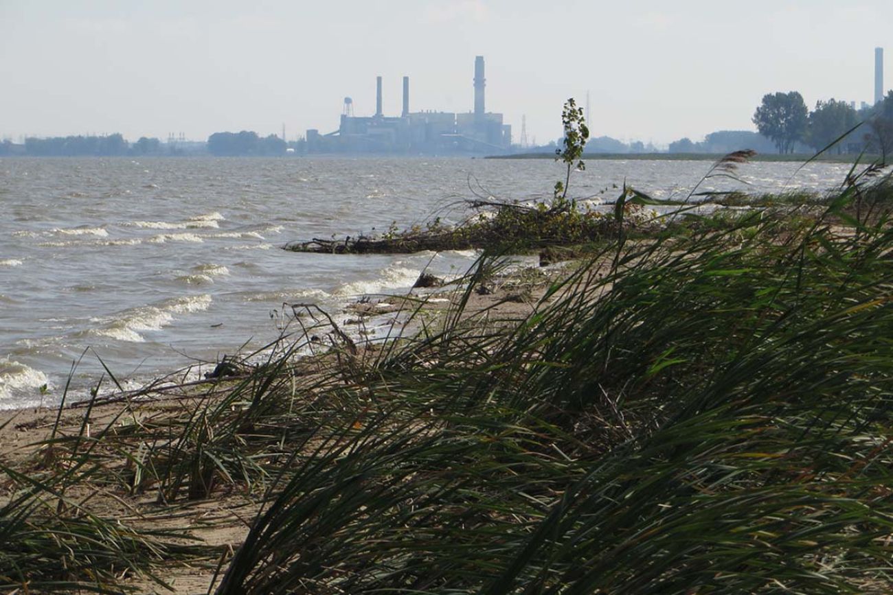 A beach with a power plant in the background