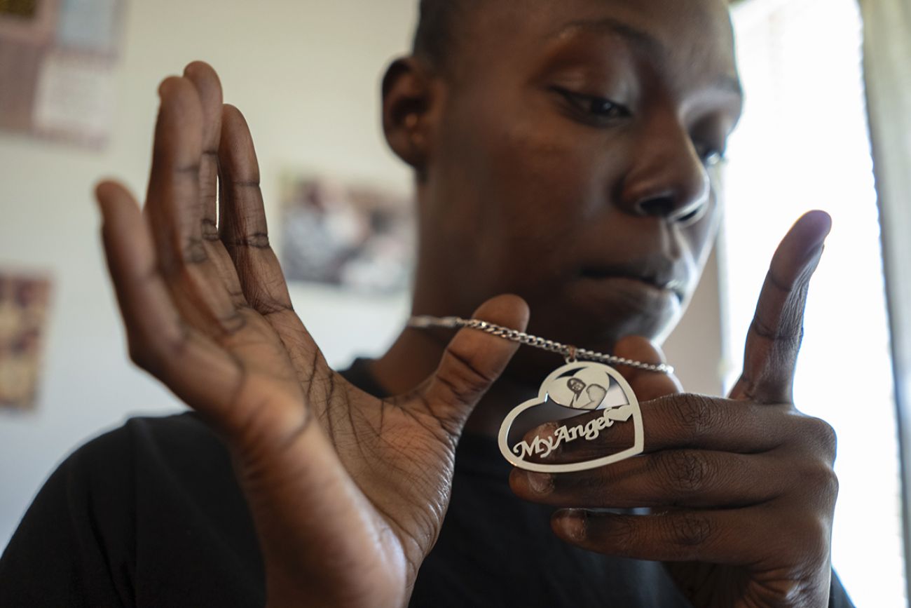 Shaquille Washington holds up a necklace that says "My Angel"