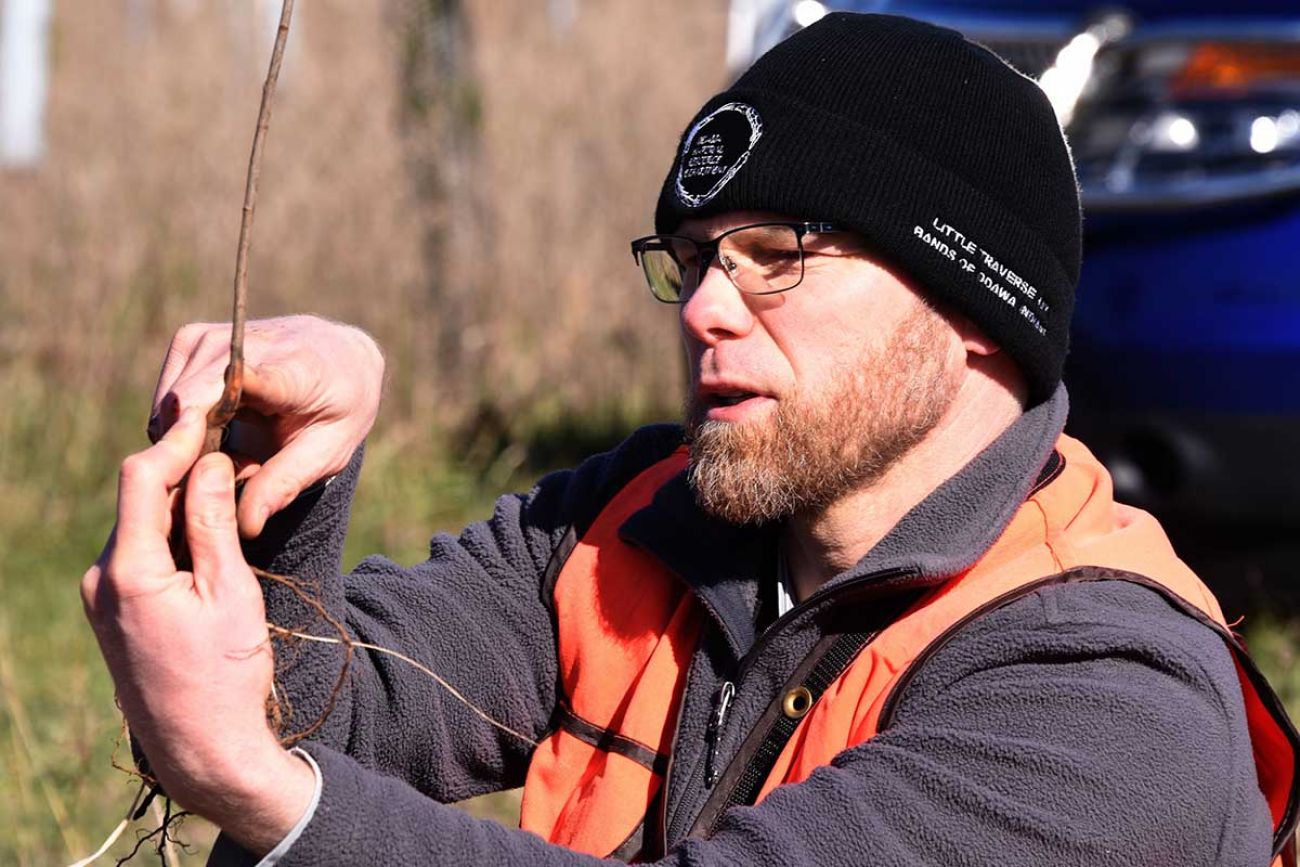 Noah Jansen, conservationist for the Little Traverse Bay Bands of Odawa Indians, explains planting depth to volunteers on Friday, April 30, at Ziibimijwang Farm near Carp Lake.