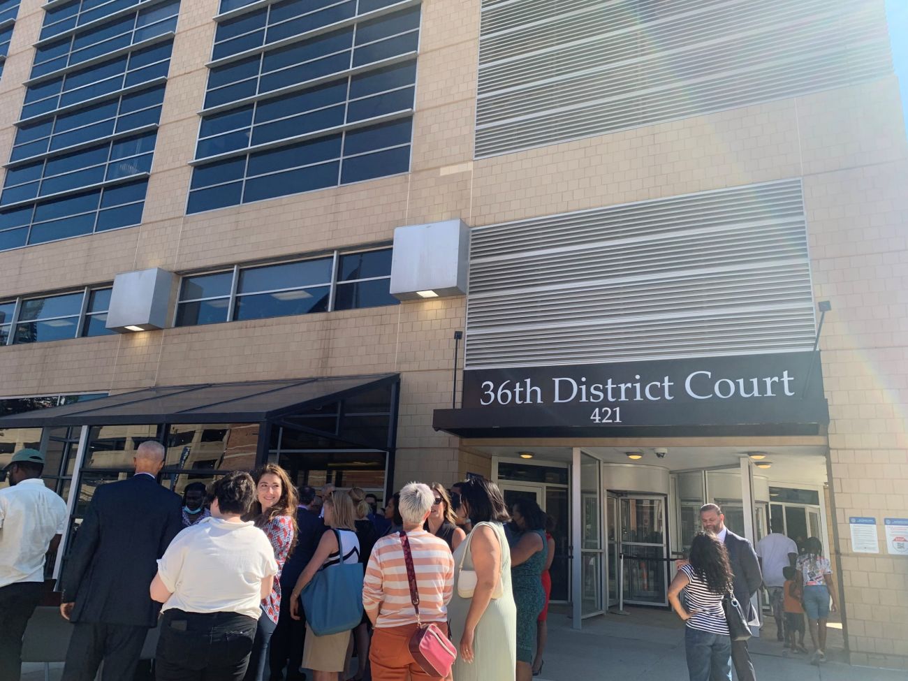 people standing in front of courthouse