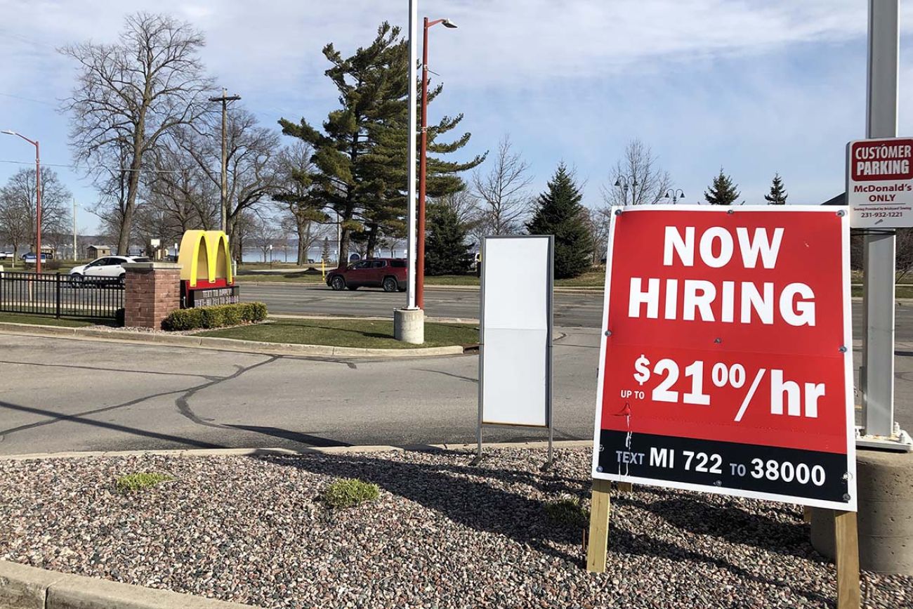 a sign outside of mcdonalds, advertising a wage of 21 an hour