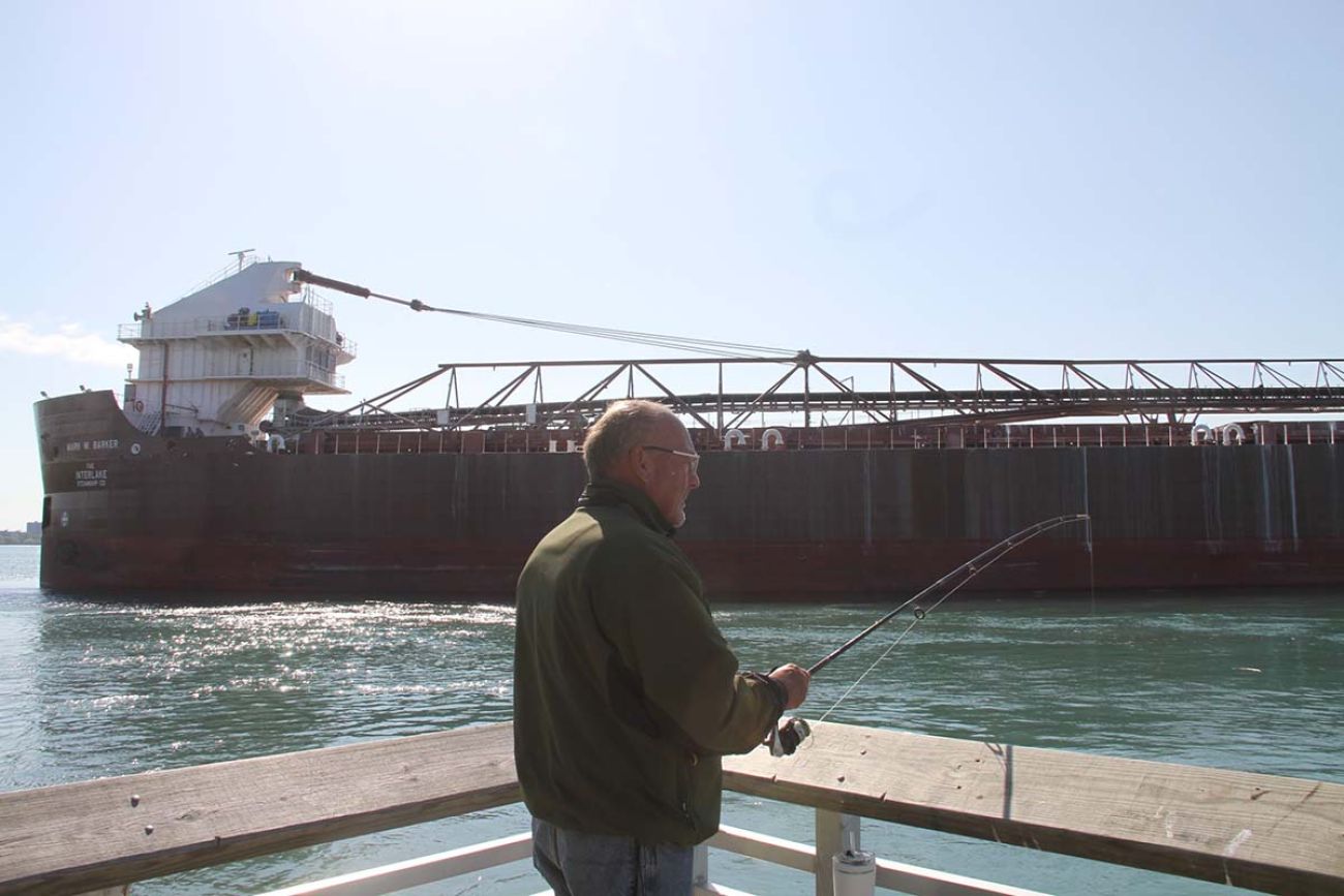 man fishing, ship in the background