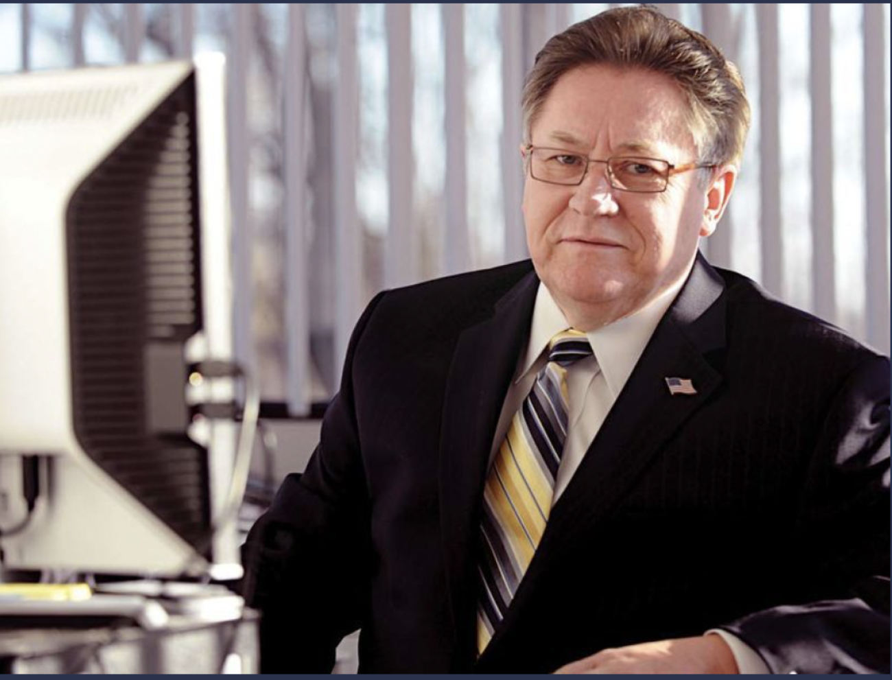 Stanley Grot sitting at a desk, posing for a picture