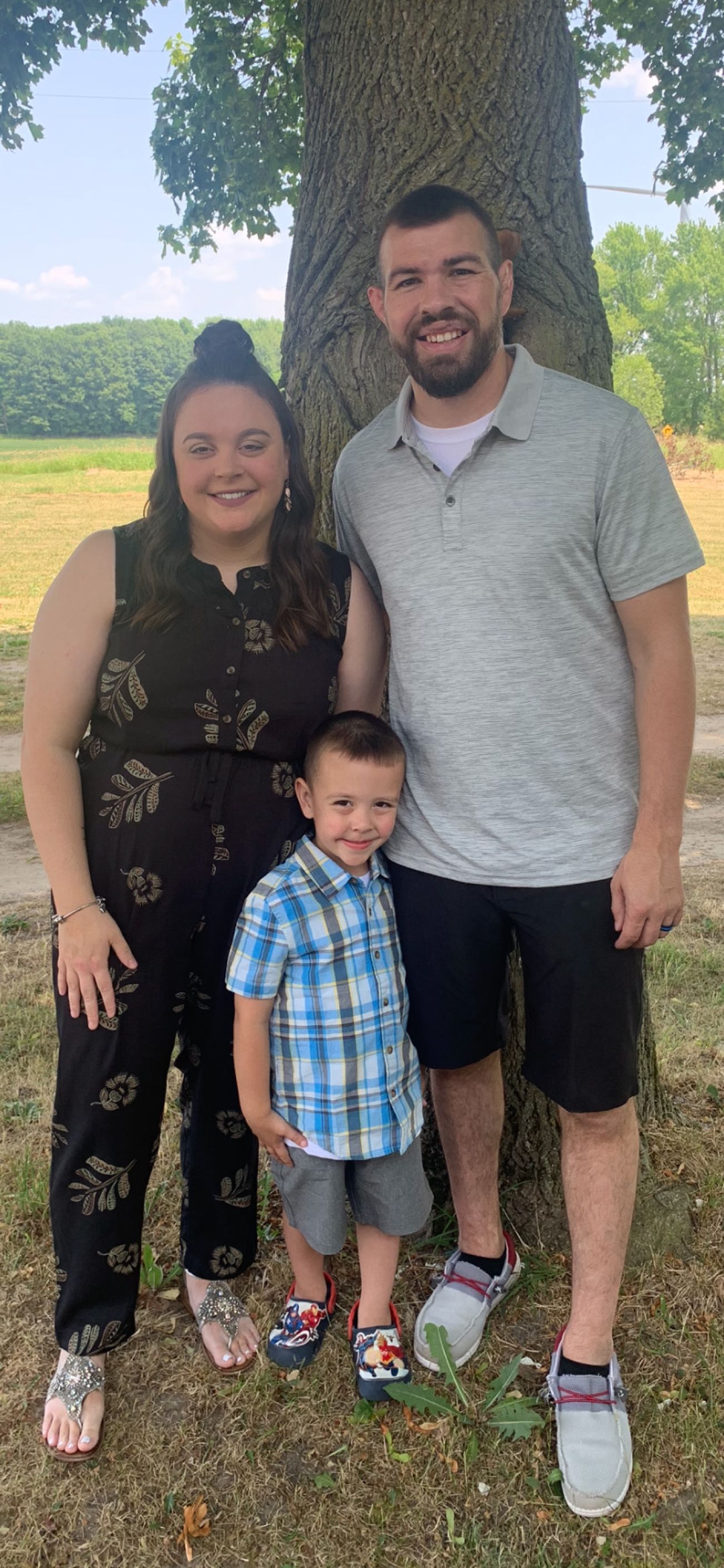 family posing in front of tree