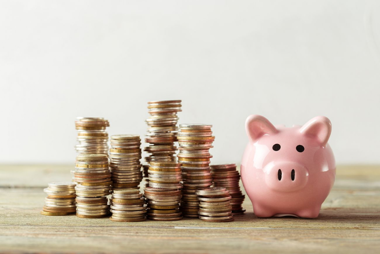 piggy bank with coins stacked next to it