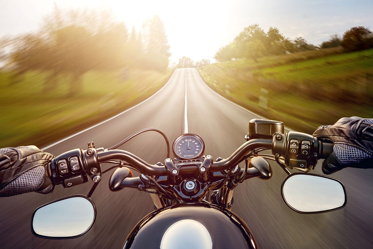 POV shot of young man riding on a motorcycle. Hands of motorcyclist on a street