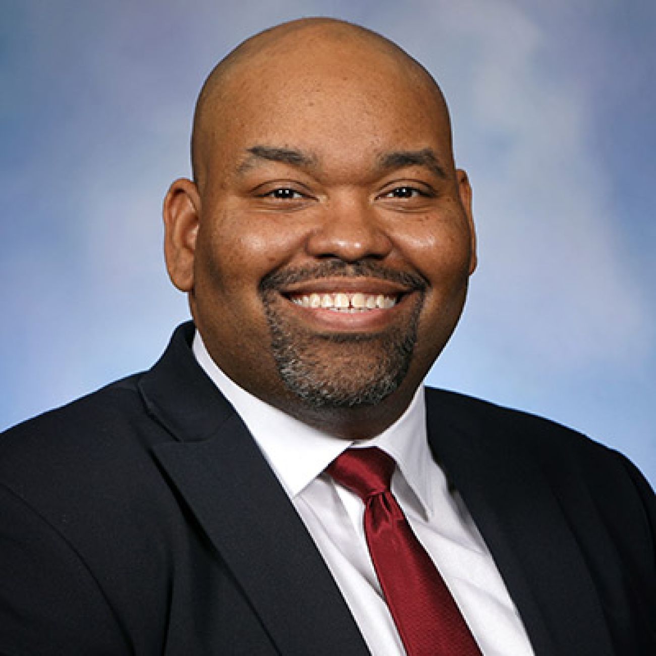 Rep. Jason Hoskins headshot. He is wearing a black suit and red tie