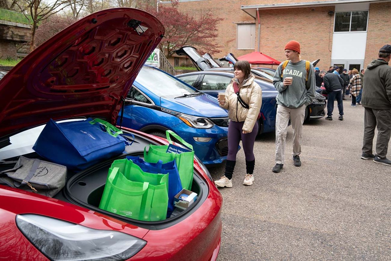 People looking at line of EV cars