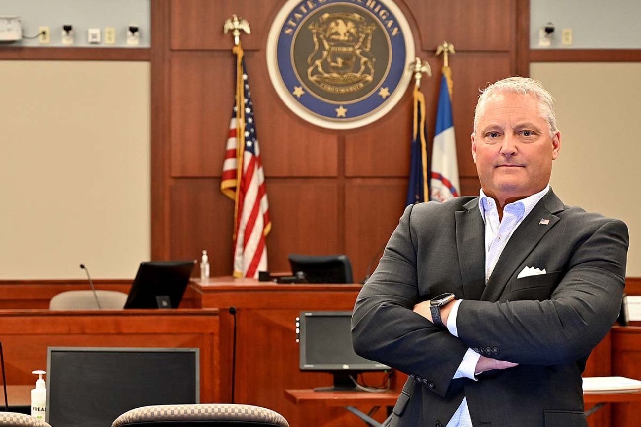 Ingham County Prosecutor John Dewane standing in a courtroom 