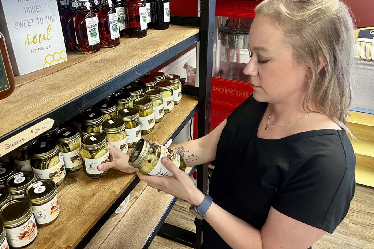 Elyse Moore looking at jars on a shelf 