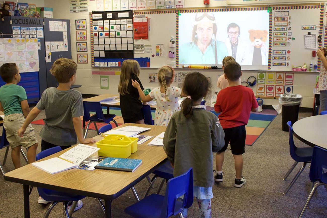 Young students looking at a screen in a classroom