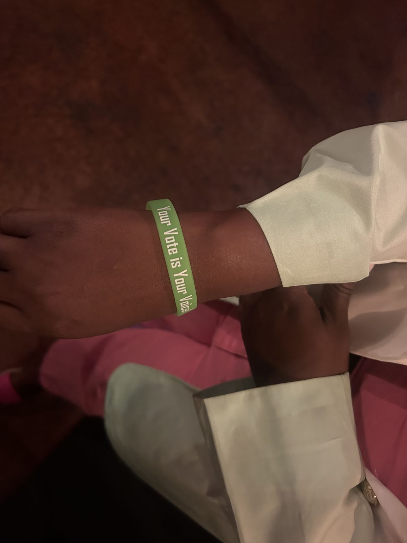 A green wristband that says "Your Vote is Your Voice"