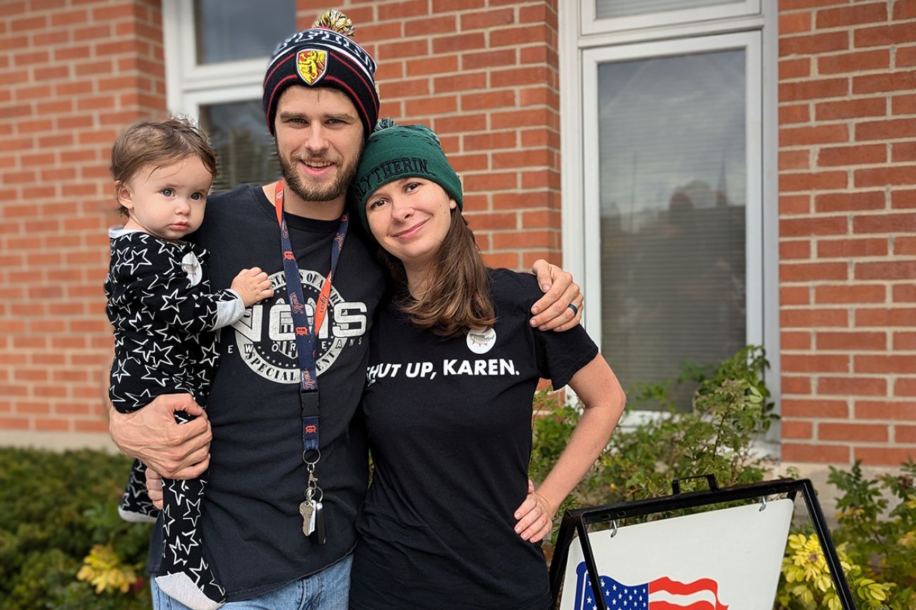 Sarah and John Fowler pose for a photo with their child in arms