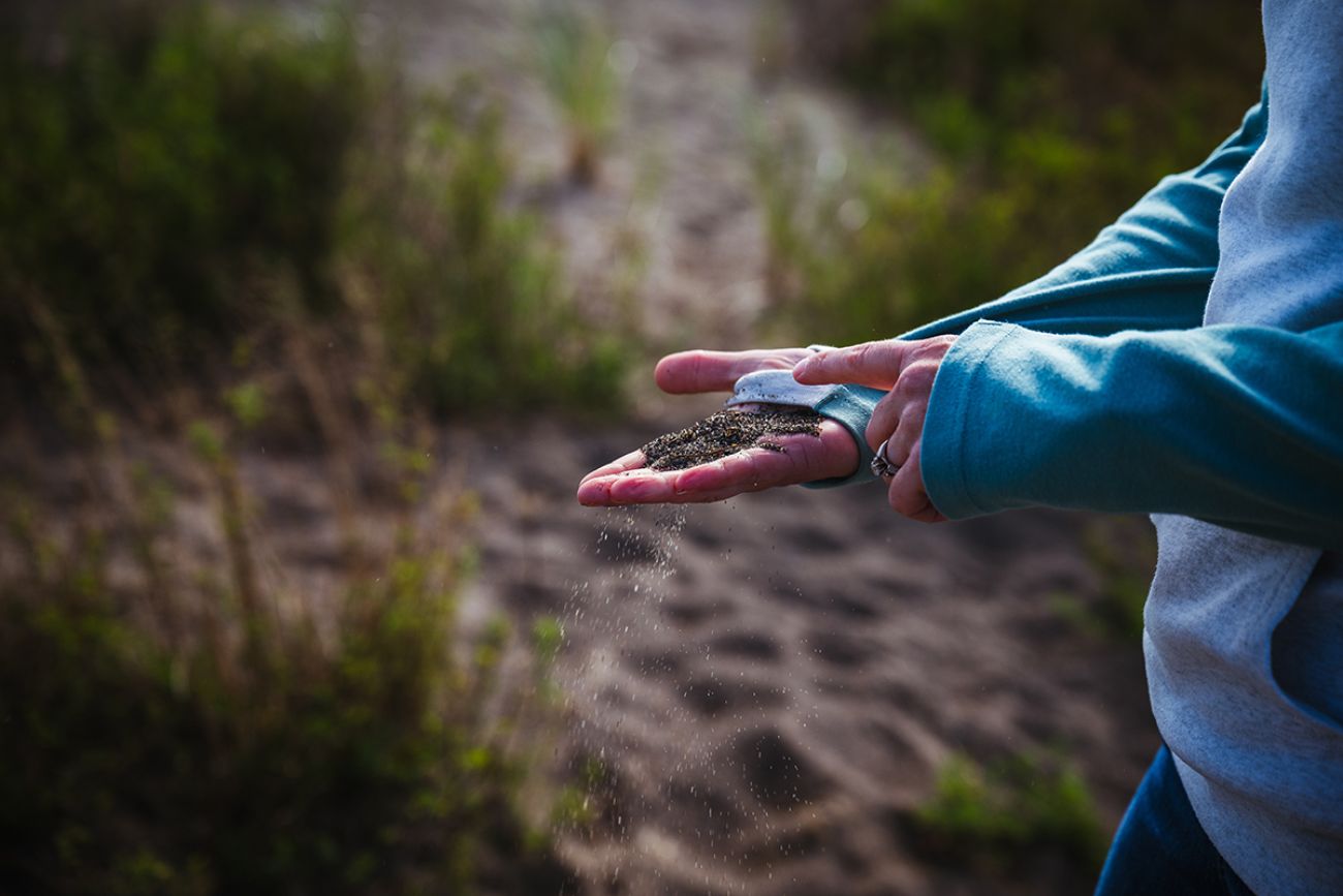 Erin Johnston has her hand out, showing stamp sands