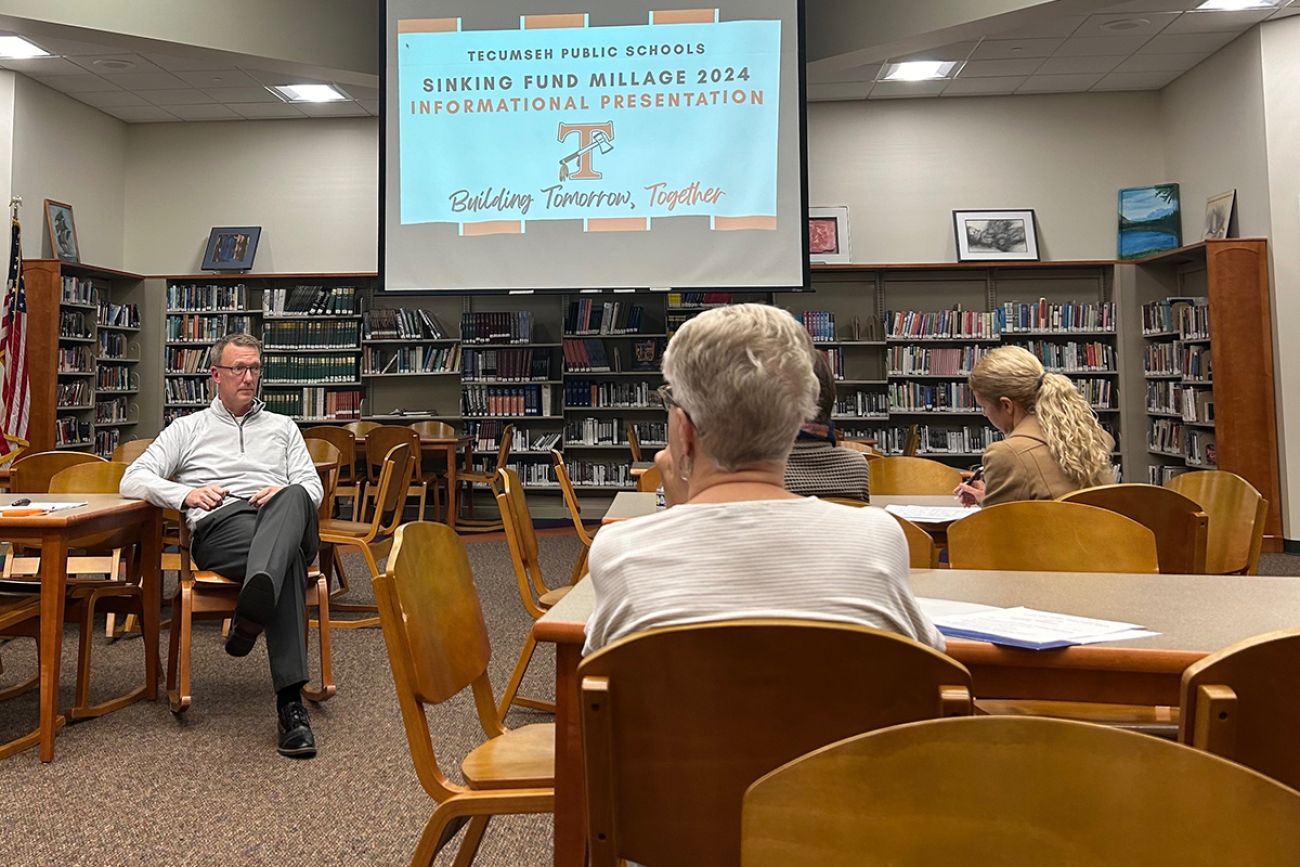 Tecumseh Public Schools Superintendent Matt Hilton sitting in a school library