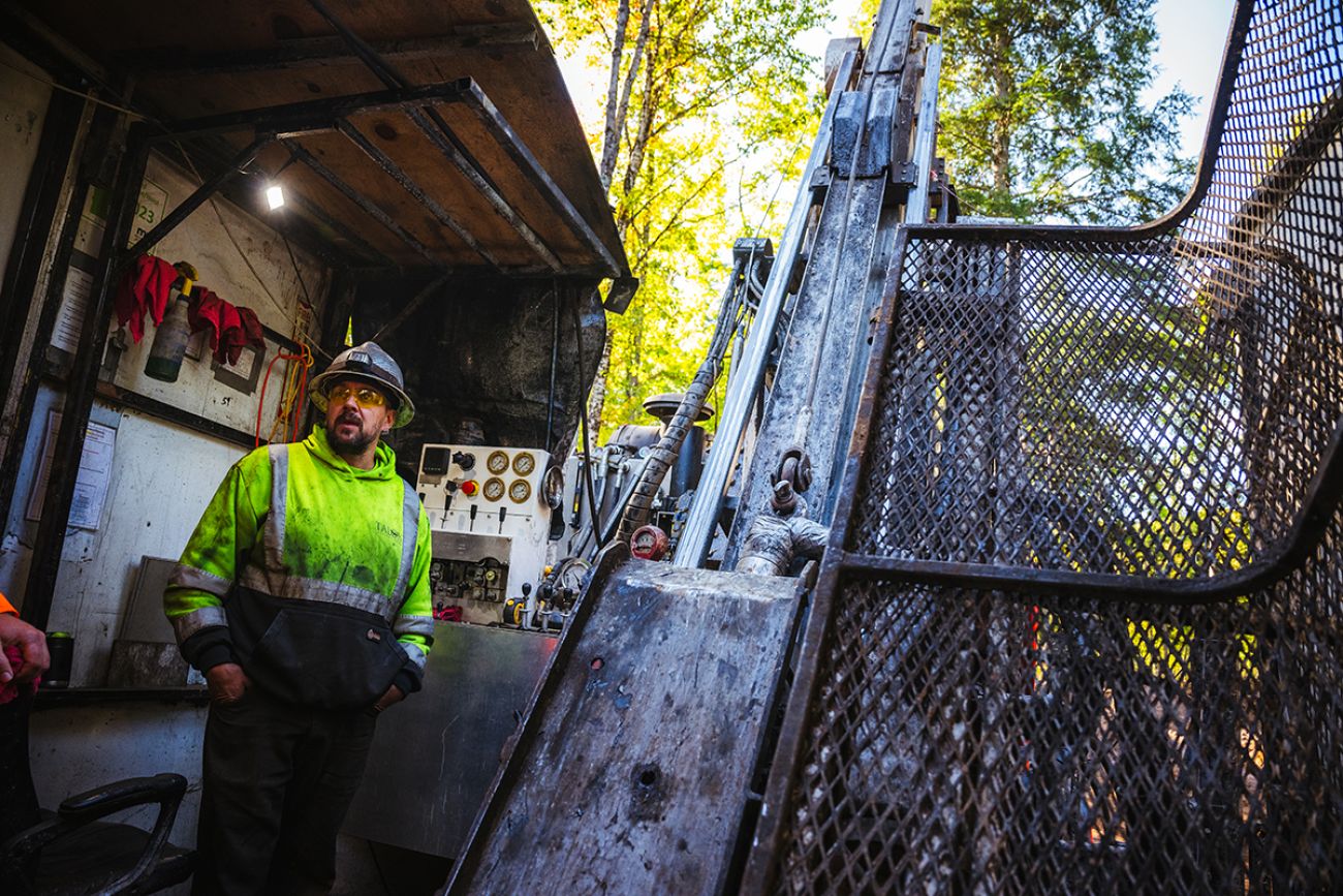 A man is hardhat and bright green shirt