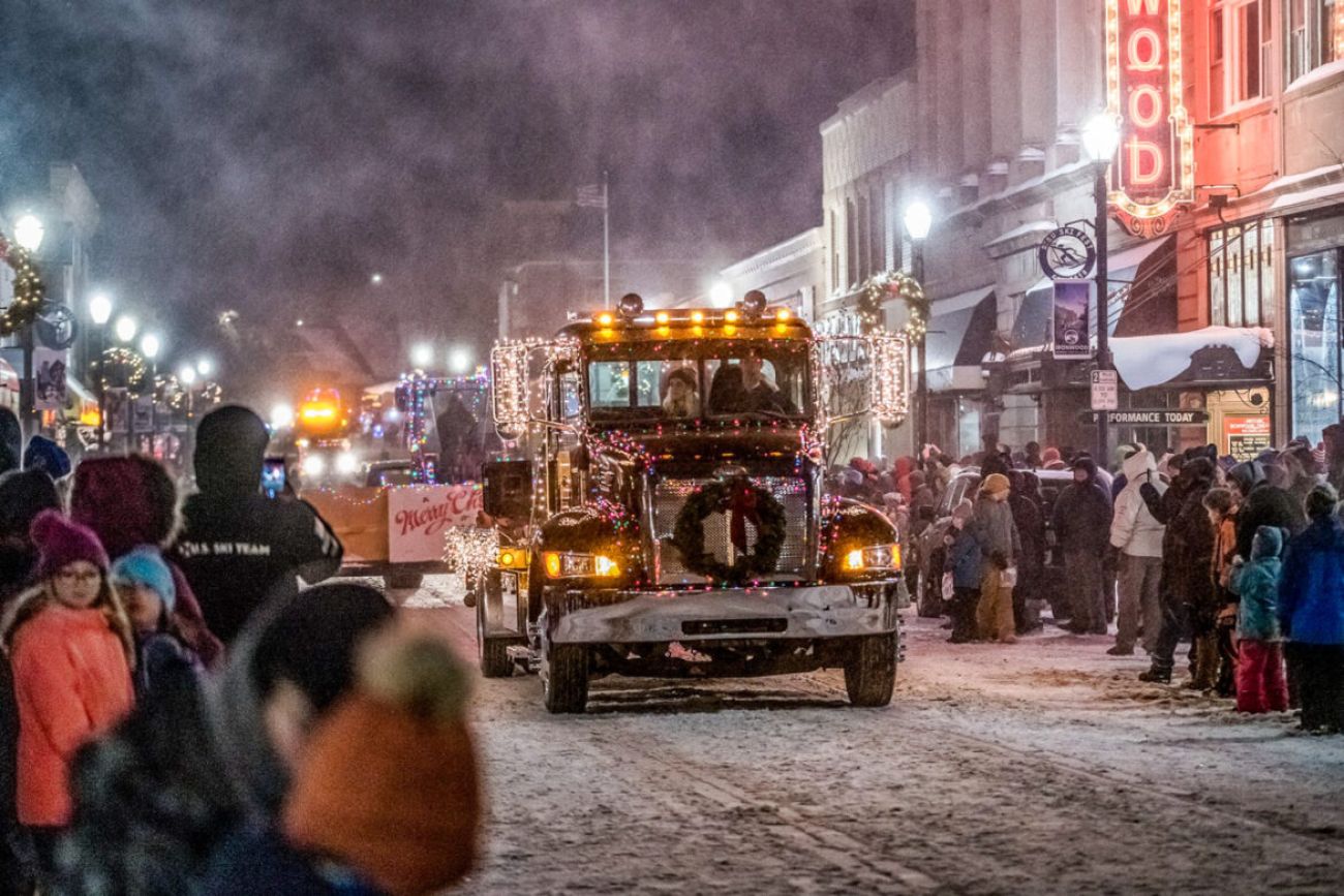 Jack Frost Festival of Lights Parade. A truck decorated with Christmas lights goes down a snowy street for a parade