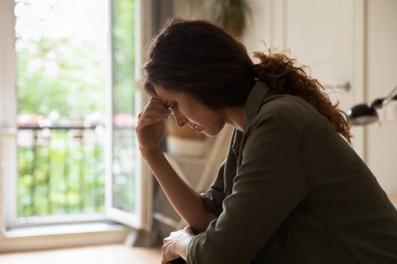 Woman sits sadly