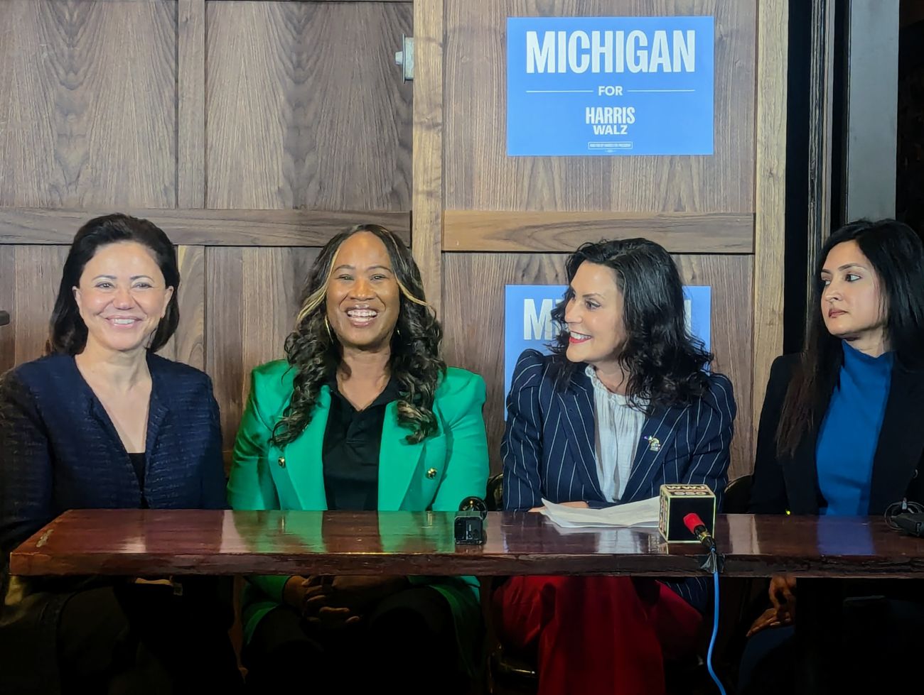 Michigan Gov. Gretchen Whitmer sits at a table with state House candidate Shadia Martini, UAW Region 1 Director LaShawn English and state House candidate Aisha Farooqi