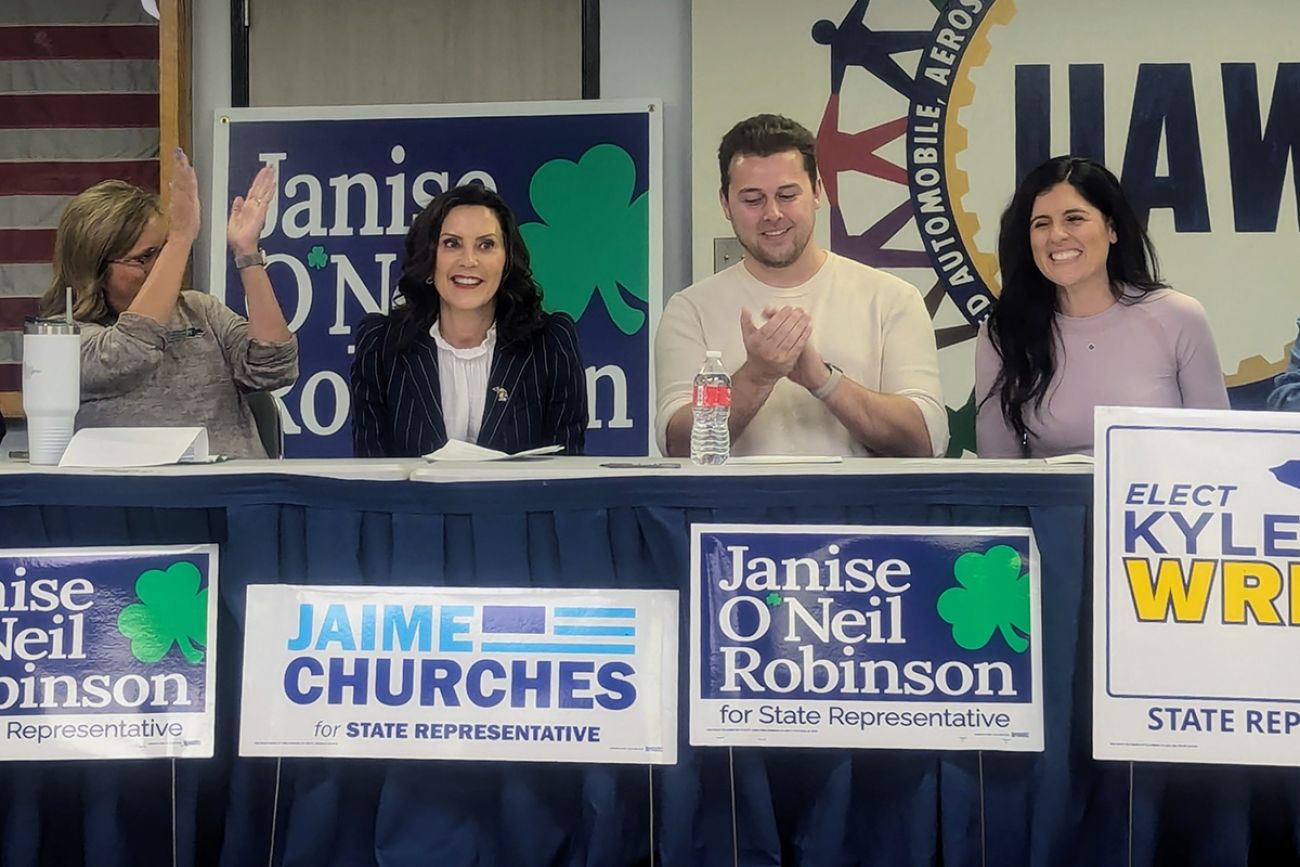 Gov. Gretchen Whitmer sitting at a table with state Rep. Jamie Churches and Michigan House candidates Janise O’Neil Robinson and Kyle Wrigh