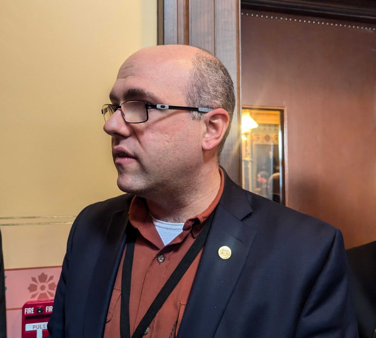 Sen. John Cherry, D-Flint, wearing a blue suit jacket and orange shirt