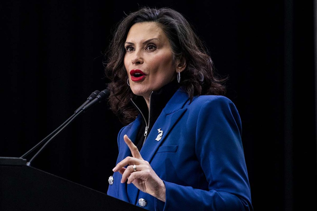 Gov. Gretchen Whitmer, wearing a blue jacket, speaks at the Detroit Auto Show