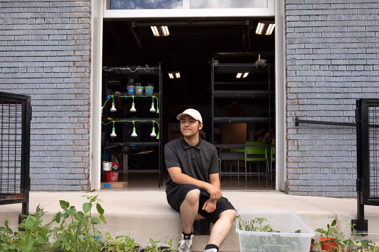 Lucian O'Donnell sits the ground in front of nonprofit United Neighborhood Initiatives' Los HQ