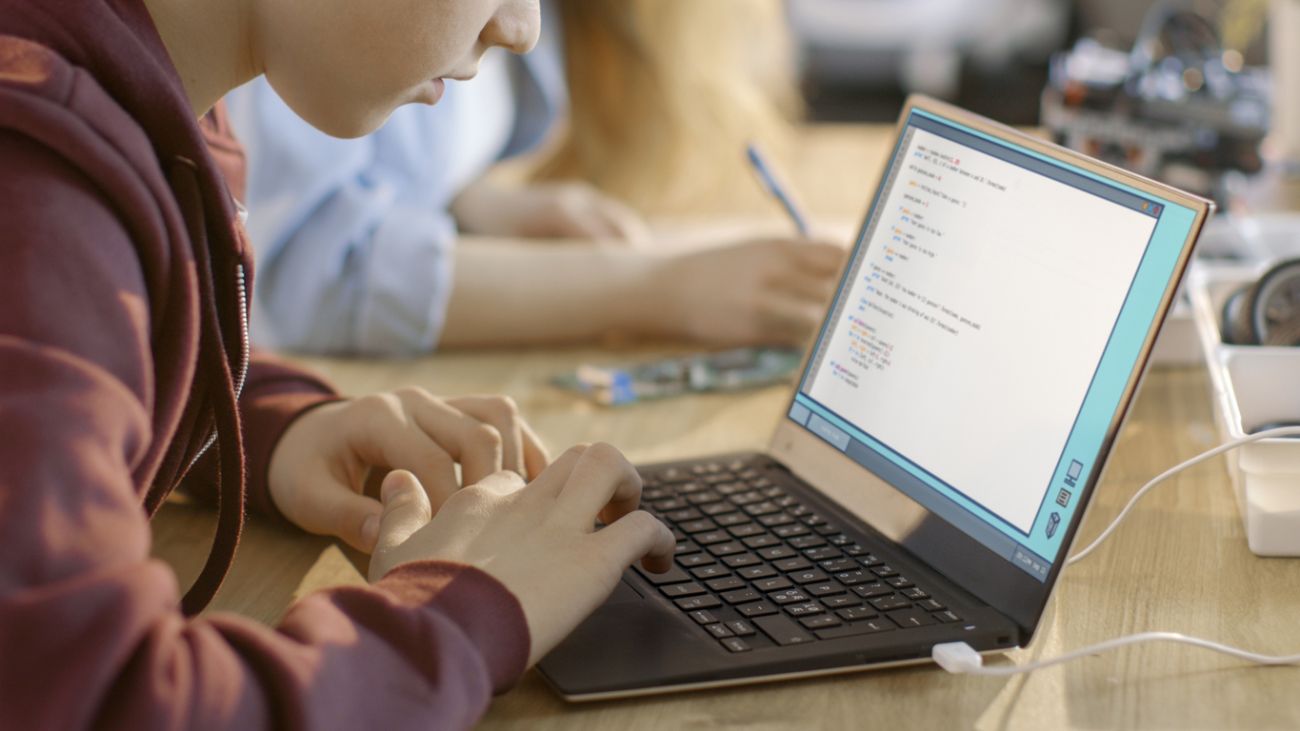 Young boy looks at a laptop in a classroom