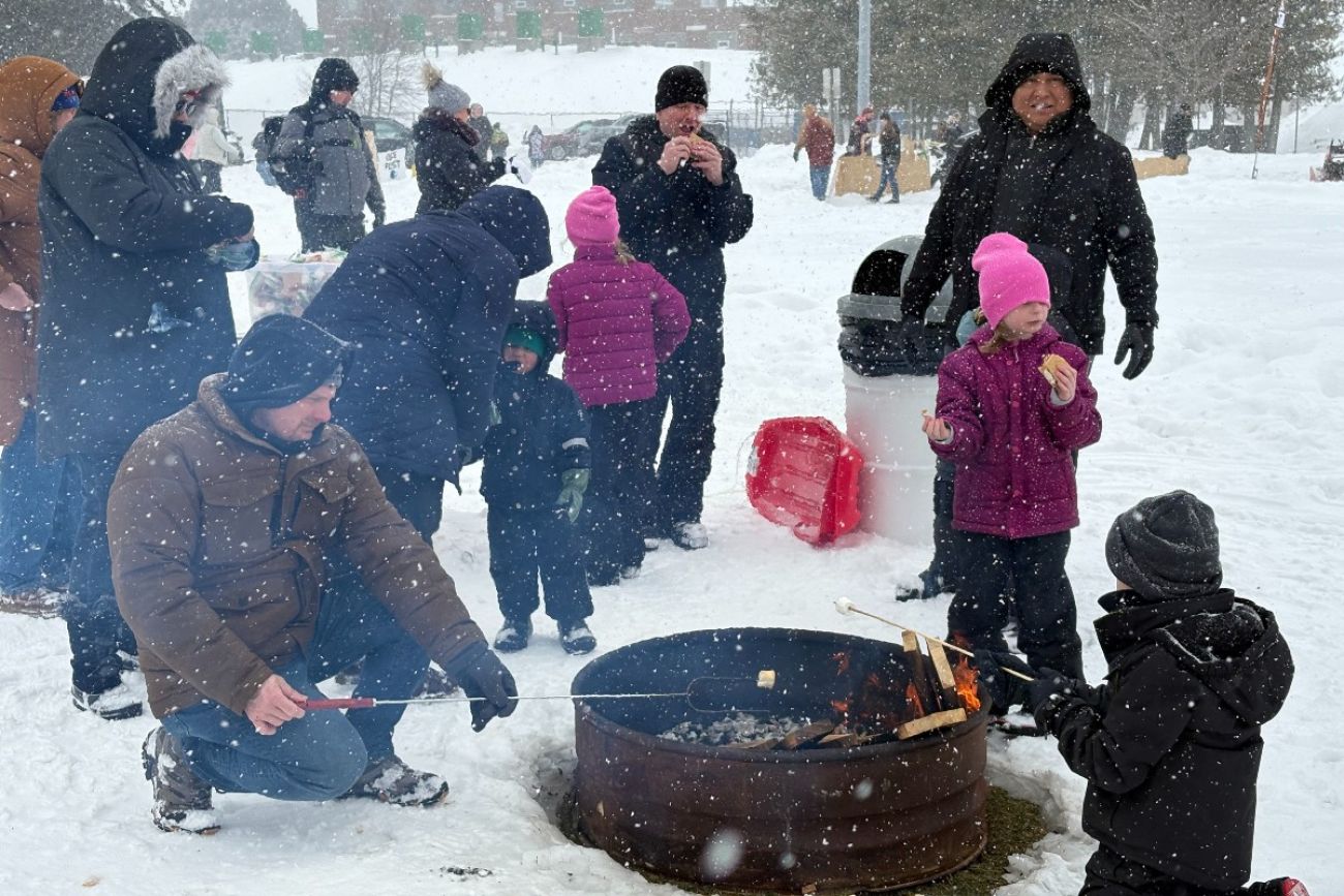 People standing around a fit pit in Alpena, Michigan. 