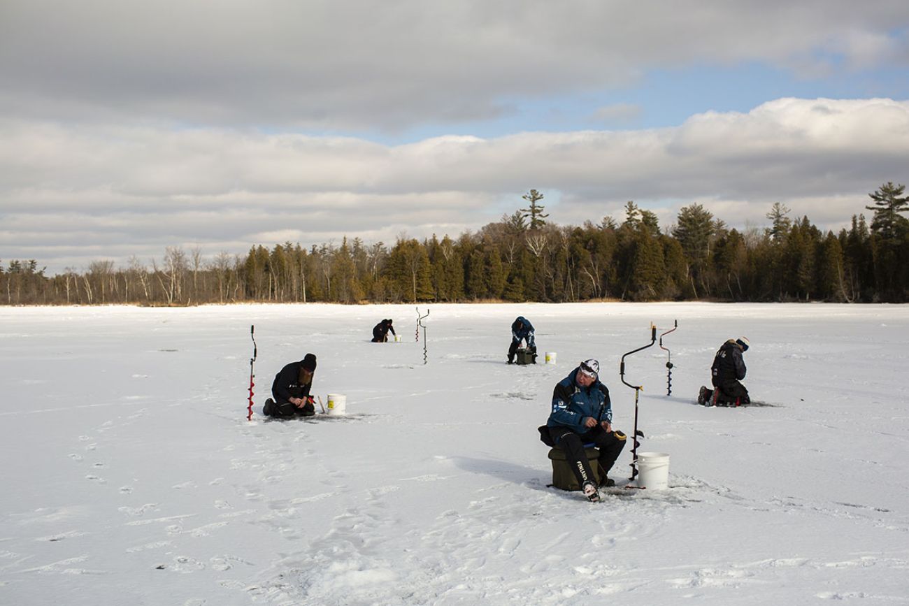 Five anglers on the frozen lake. 