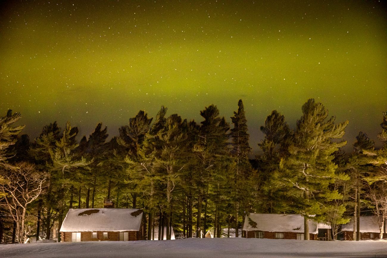 Green lights over the cabins at the Keweenaw Mountain Lodge and a bunch of trees.