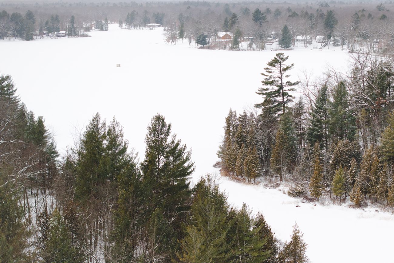 An aerial view of a snowy Woodland Lake in Michigan. 