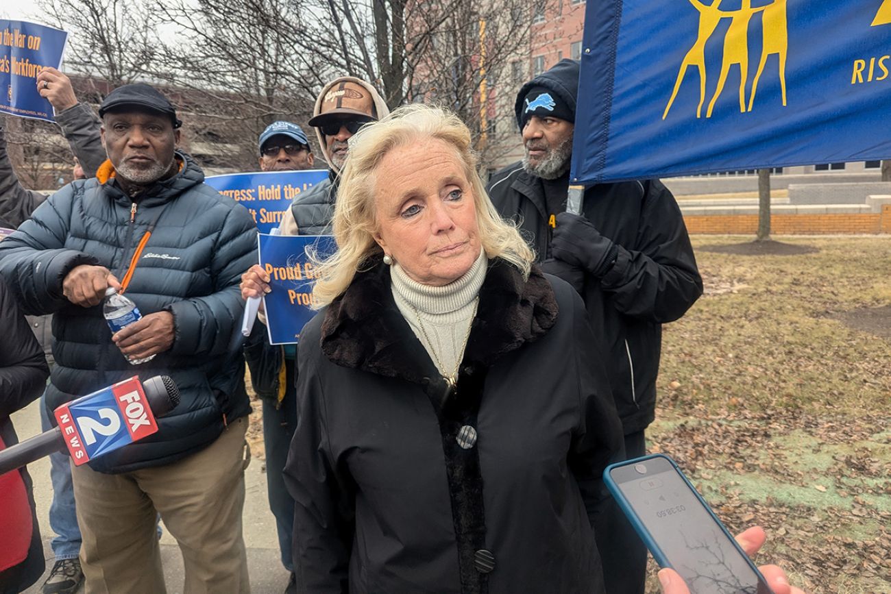 US Rep. Debbie Dingell standing next to protestors. 