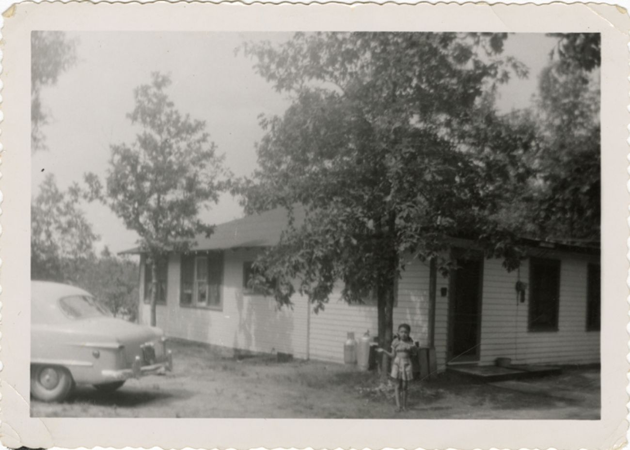 A black and white photo of a little girl in Idlewild. 