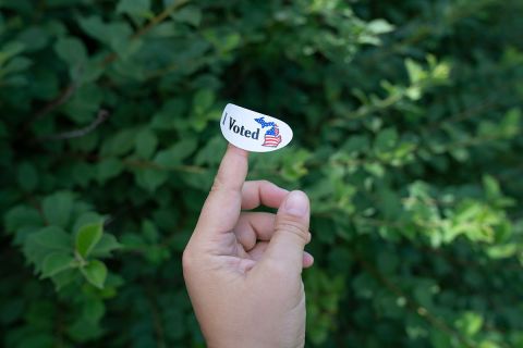 someone holding i voted sticker