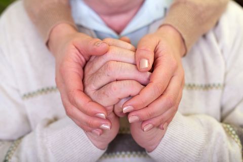 Close up picture of elderly hands with young caretaker's hands