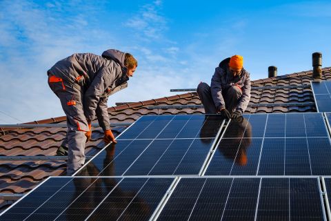 Workers installing solar cell farm power plant eco technology.