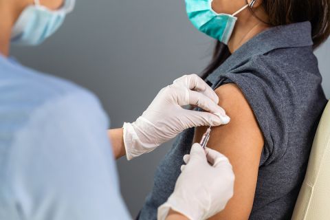 close up doctor holding syringe and using cotton before make injection to patient in medical mask.