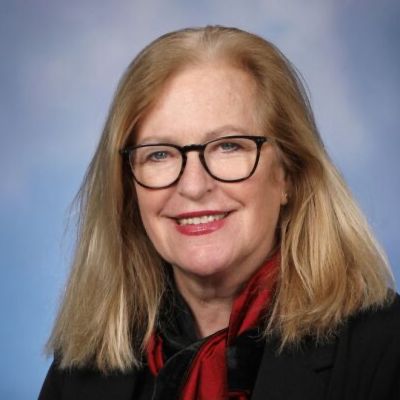 Woman's headshot in front of a blue background