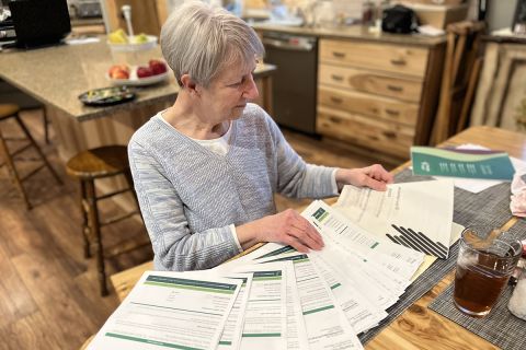 Pat Kreple looking at a bunch of bills on a table