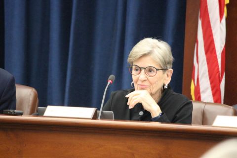 Woman sits behind desk