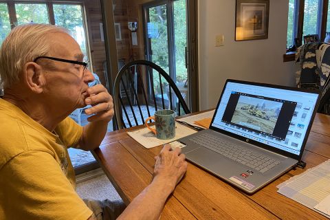 John Doyle sitting at a table looking a laptop