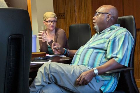 Cara Poland and Tommy Stallworth sitting on a table 