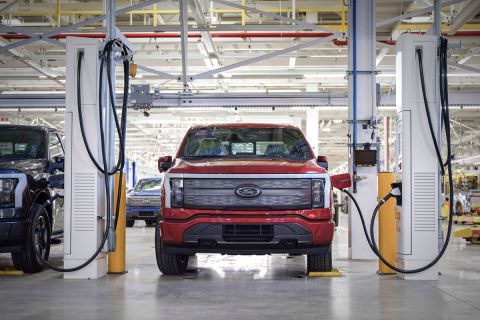 A red electric car being charged