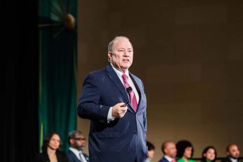 Mayor Mike Duggan, wearing a blue jacket, on the stage