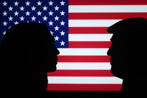 A silhouette of Kamala Harris and Donald Trump on an American flag