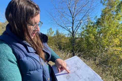 Elise Matz, standing outside, points at a map she's holding