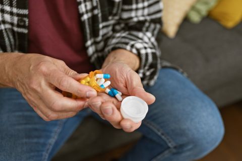 Man pours pills into hand