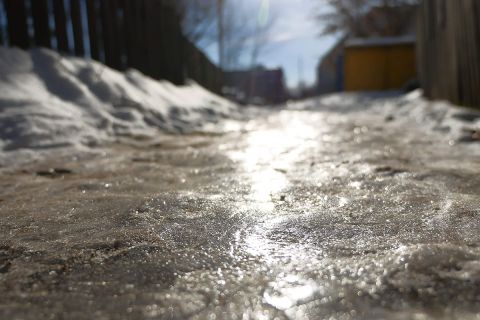 A sidewalk covered in ice and snow. 